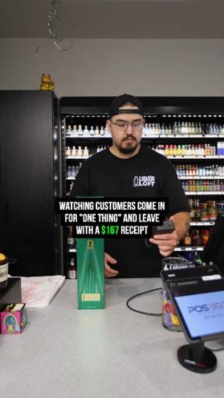 Liquor Loft team member behind the checkout counter with a bottle purchase