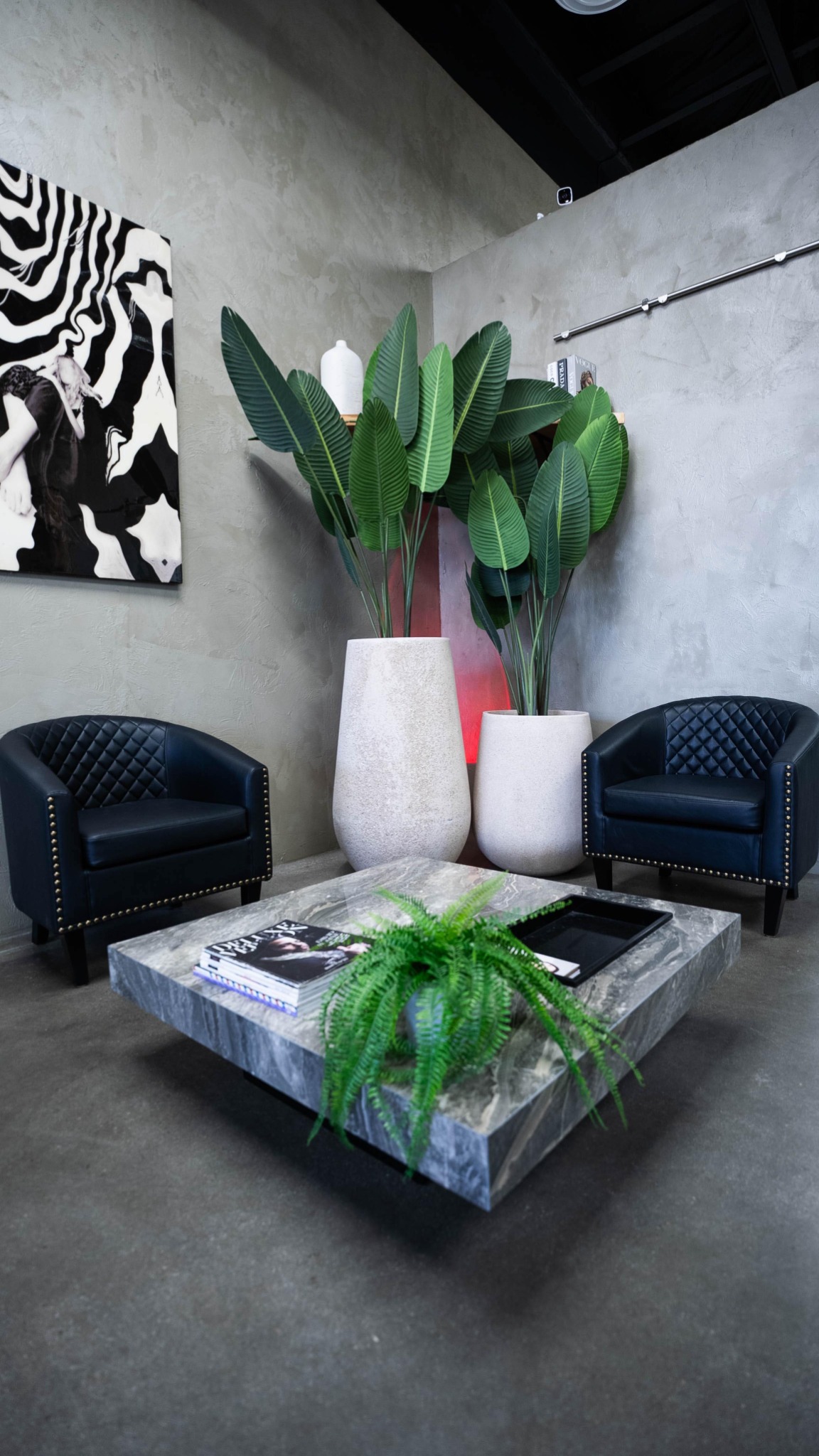 Concrete, greenery and seating inside Texture Barbershop